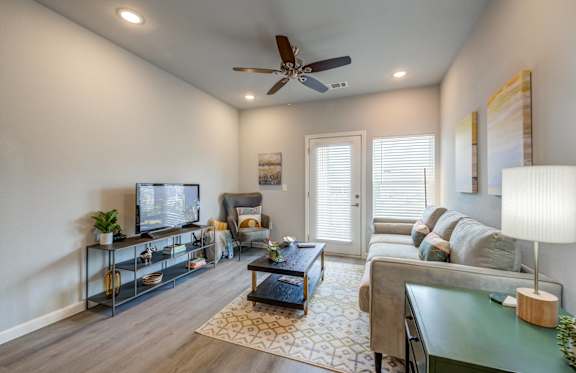 a living room with a ceiling fan and a couch