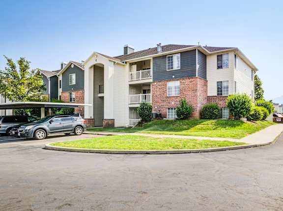 an apartment building with cars parked in a parking lot