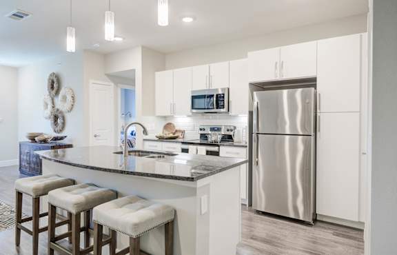 A modern kitchen with a bar stool and a countertop.