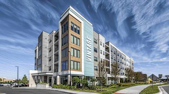 a large apartment building with a blue sky in the background