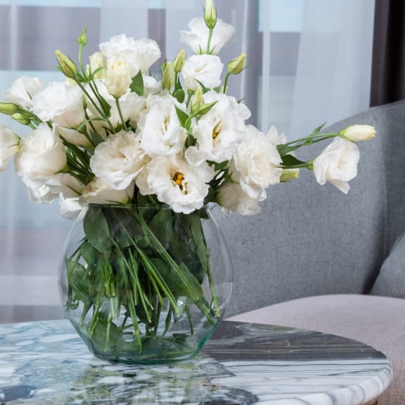a vase filled with white flowers sitting on a table