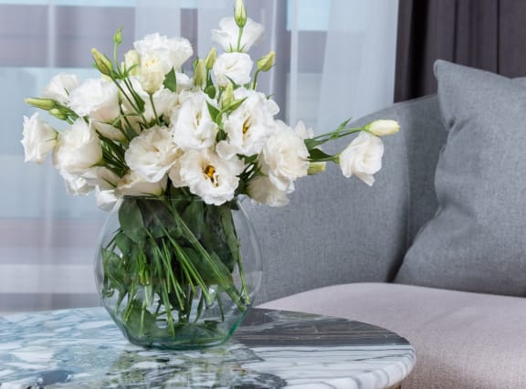 a vase filled with white flowers sitting on a table