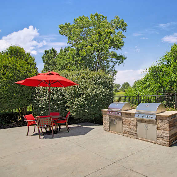 A patio with a barbecue grill and a table and chairs at Memorial Creek