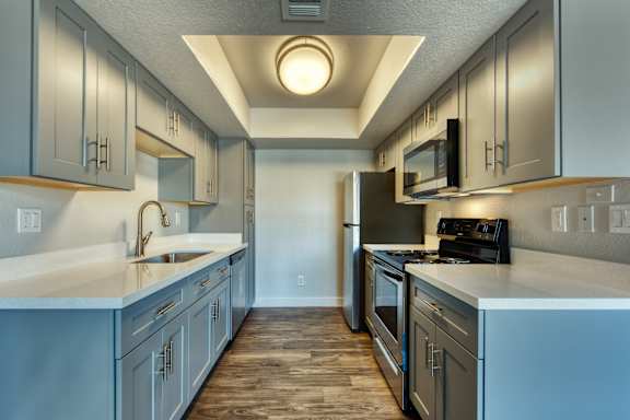 A kitchen with a refrigerator, stove, and sink.