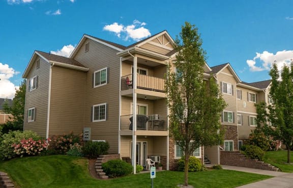 an apartment building with a balcony and trees