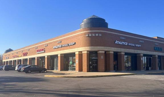 A brick building with a sign that says Athletico Physical Therapy.
