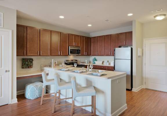 a kitchen with a large island and white chairs