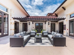 a patio with wicker furniture and a pergola