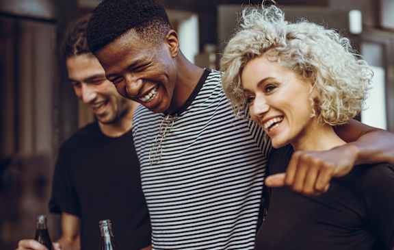 Two people laughing and pointing at something.