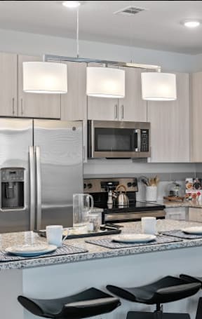 A modern kitchen with a granite countertop and stainless steel appliances.
