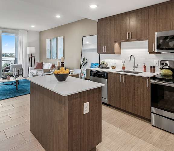 A modern kitchen with a wooden island and stainless steel appliances.