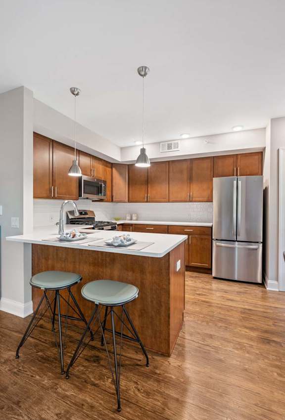 A modern kitchen with wooden cabinets and stainless steel appliances.