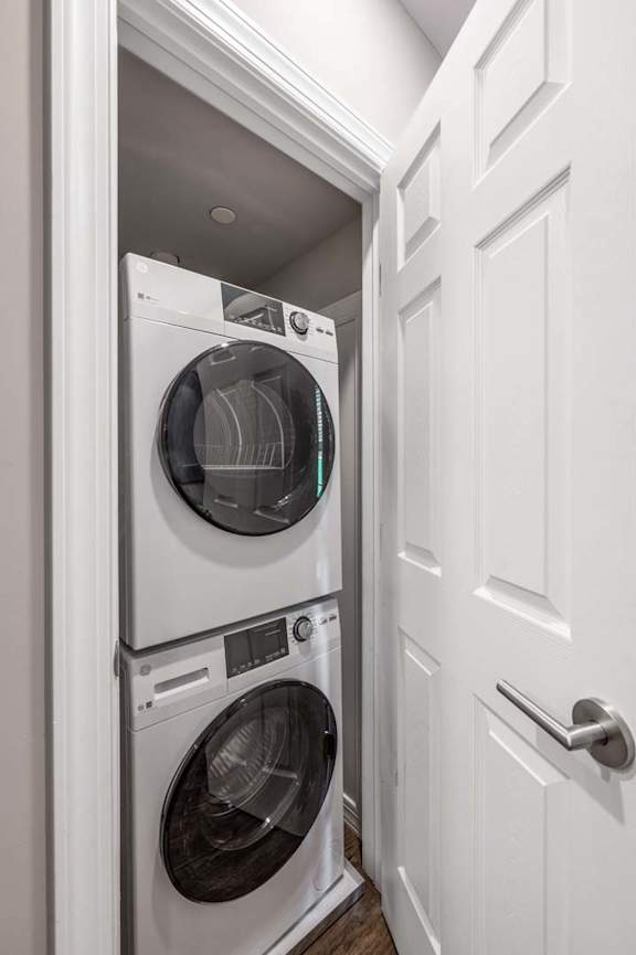 A white door is open to reveal a white washer and dryer.