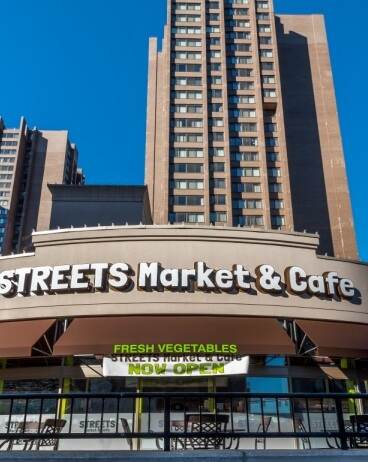 A large building with a sign that says "Streets Market & Cafe" in front of it.