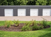 Thumbnail 14 of 46 - A row of garage doors at Countryside Estates Apartments, Plymouth
