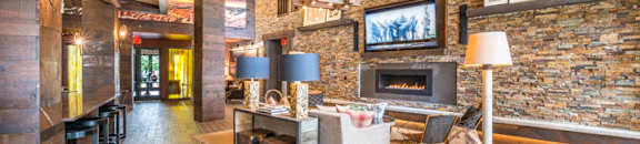 Lounge Area With Stone Fireplace at Aviator West 7th, Fort Worth