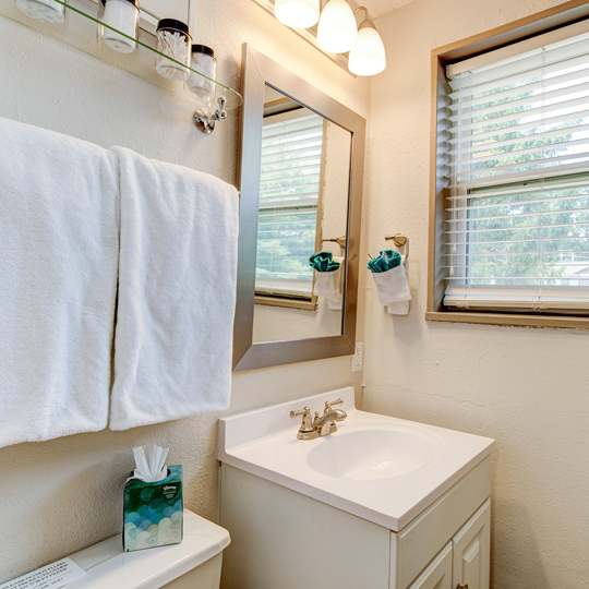 A white towel hangs on a towel rack in a bathroom.