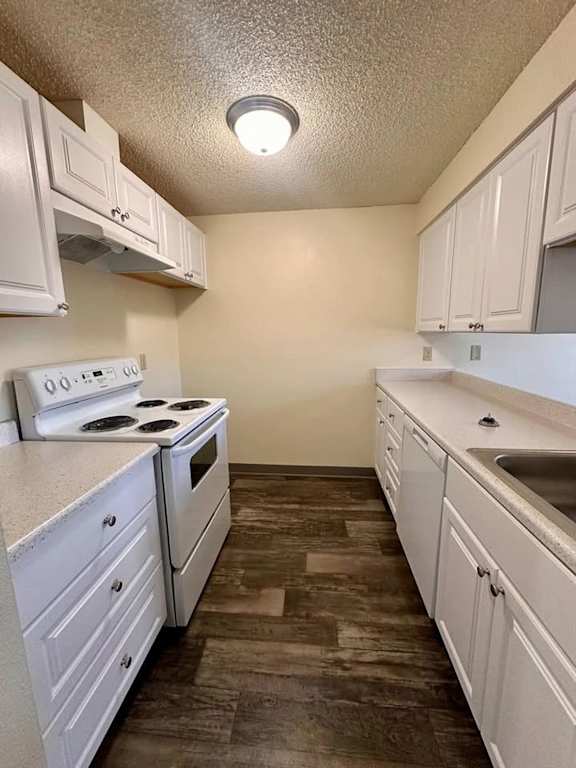 A kitchen with white cabinets and a stove top oven.
