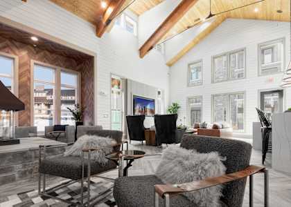 A modern living room with a black and white checkered rug and a wooden coffee table.