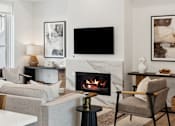 Thumbnail 10 of 51 - A modern living room with a fireplace and a flat screen TV mounted on the wall.