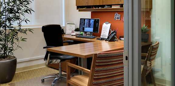 A conference room with a wooden table and chairs.