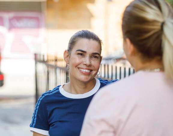 two women talking to each other on the street
