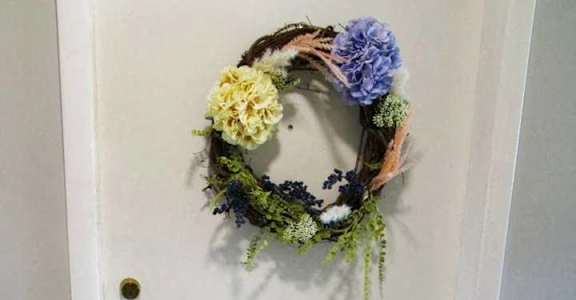 A door with a wreath and a doormat that says "so happy you're here".