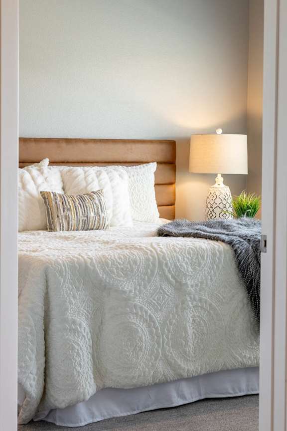 a bedroom with a white bed and pillows on it