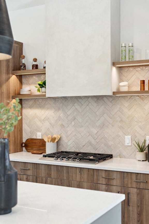 A modern kitchen with a white countertop and wooden cabinets.