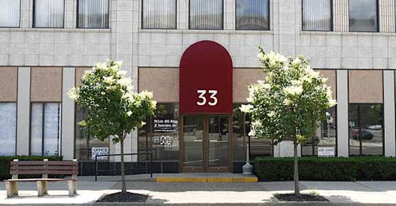 A building with the number 33 on it has a red arched entrance.