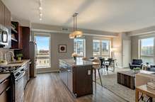 A modern kitchen with dark wood floors and stainless steel appliances. at The M on Hennepin, Minneapolis, Minnesota