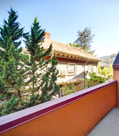 a balcony with a view of a house and some trees