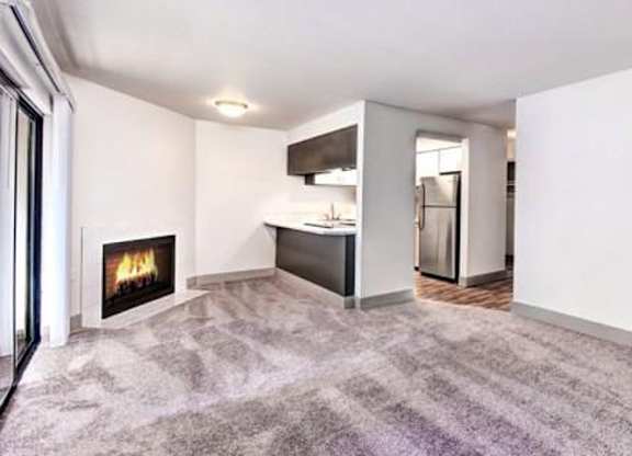 Milton Apartments - Autumn Village Apartments - Living Room, Fireplace, Kitchen, and Deck
