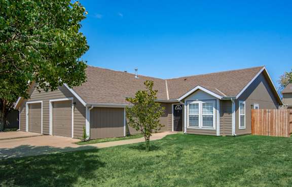 A house with a brown roof and a grey garage door.