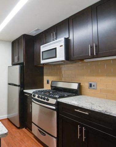 a kitchen with a sink stove refrigerator and microwave
