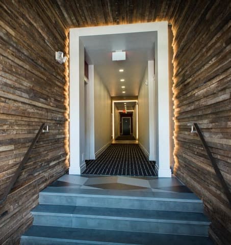 a hallway with wood paneling and a staircase