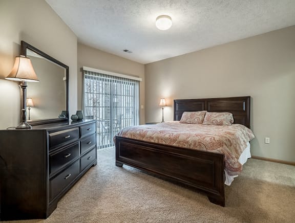 Interiors- Bedroom that easily fits a large bed and dresser at Stone Creek Villas Apartments in Omaha Nebraska
