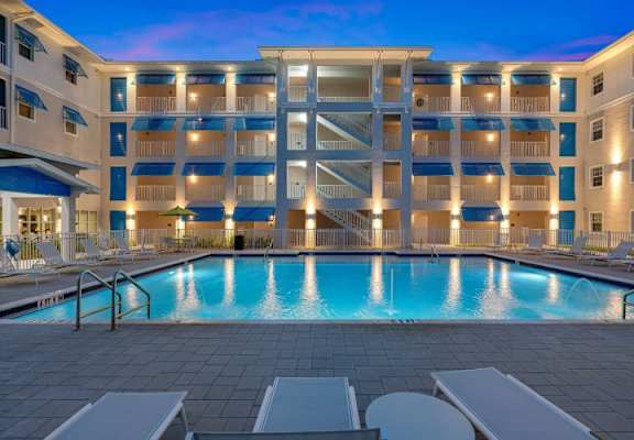 A large building with a pool in front of it.