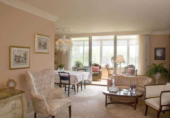 A living room with a chair, a sofa, a coffee table, and a chandelier.