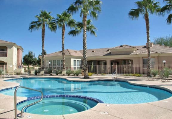 a swimming pool with palm trees in front of a house