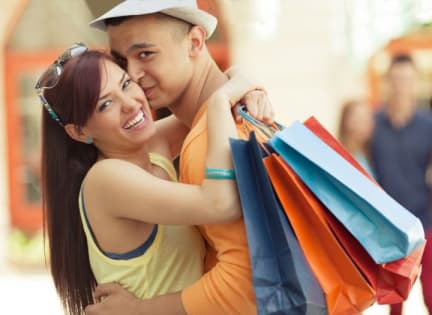 a couple hugging and holding shopping bags