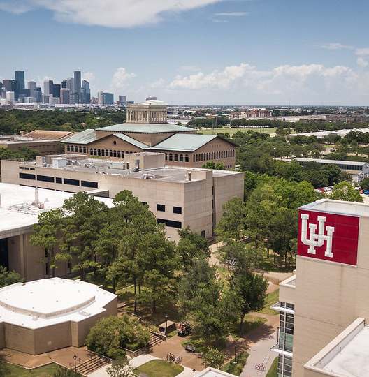 A view of a university campus with a city skyline in the background.