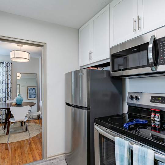 A modern kitchen with a stainless steel refrigerator and microwave.