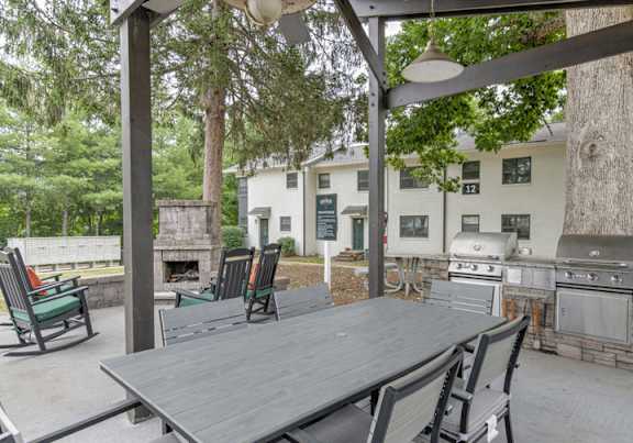 A patio with a table and chairs under a pergola.