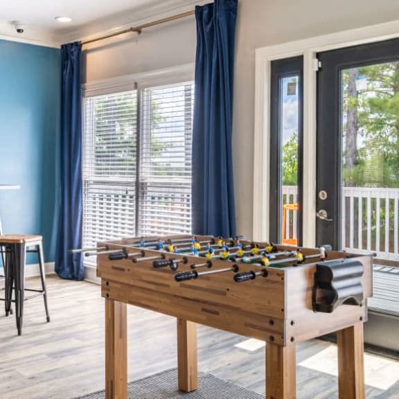 a game room with a foosball table and a patio