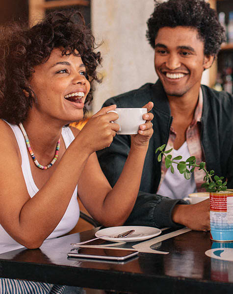 a man and woman sitting at a table drinking coffee