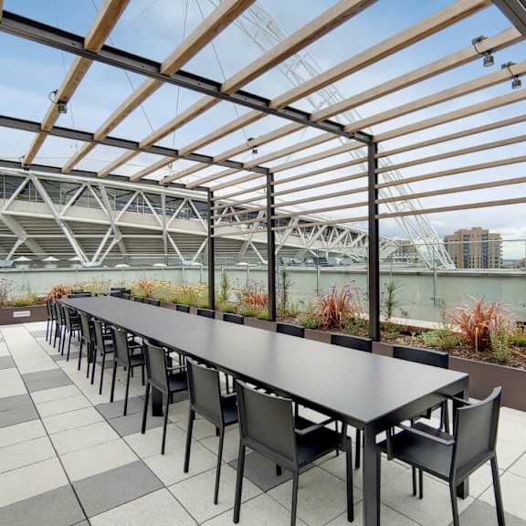 A long table with chairs is set up on a patio with a view of a stadium at Beton Apartments, Wembley, HA9 0SL
