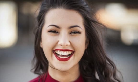 a woman in a red dress with a smile on her face