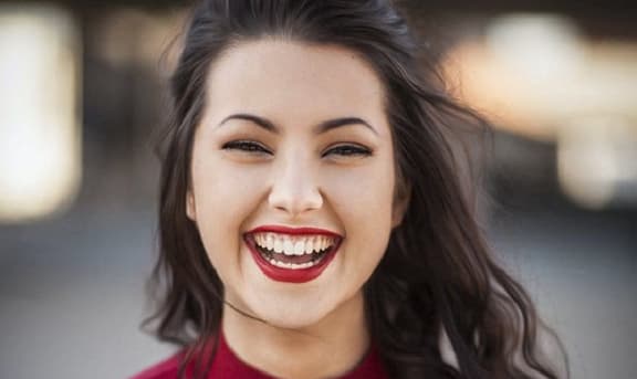 a woman in a red dress with a smile on her face