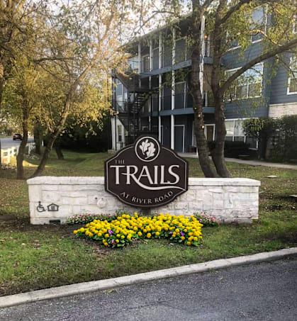 a sign for the trails in front of a building